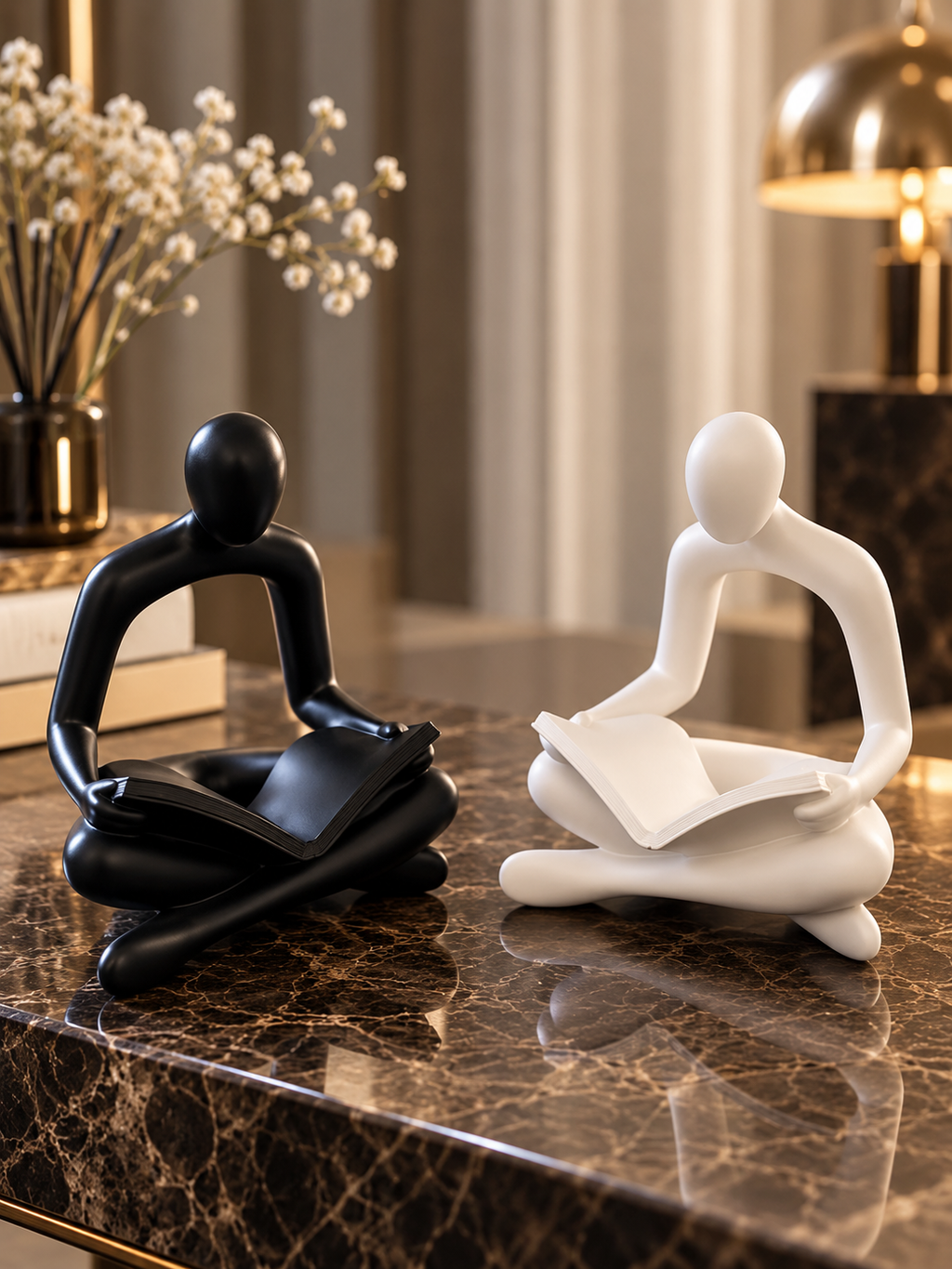 Set of 2 black and white reading statues.